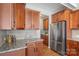 Kitchen boasts granite countertops, stainless steel refrigerator, and wooden cabinetry at 3211 Gilroy Dr, Fort Mill, SC 29707