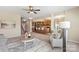 Open-concept living room featuring plush carpeting, a ceiling fan, and view of the kitchen and staircase at 3211 Gilroy Dr, Fort Mill, SC 29707