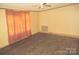 Large bedroom showcasing neutral walls, modern ceiling fan, and a window with orange curtains at 3942 Benny Shrum Ln, Maiden, NC 28650