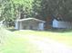 Exterior view of outbuildings with a well-maintained lawn and a tree-lined backdrop at 3942 Benny Shrum Ln, Maiden, NC 28650