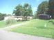 Property exterior showing a well-maintained lawn, surrounding trees, and outbuildings at 3942 Benny Shrum Ln, Maiden, NC 28650