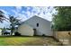 Backyard featuring green grass, a wooden privacy fence, and mature trees creating a serene outdoor space at 4009 Egrets Nest Ct, Mount Holly, NC 28120
