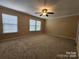 Spacious carpeted bedroom featuring a ceiling fan and natural light from the many windows at 4009 Egrets Nest Ct, Mount Holly, NC 28120