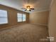 Spacious carpeted bedroom featuring a ceiling fan and natural light from the many windows at 4009 Egrets Nest Ct, Mount Holly, NC 28120