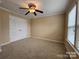 Cozy bedroom featuring a ceiling fan, closet, neutral carpet, and a window for natural light at 4009 Egrets Nest Ct, Mount Holly, NC 28120