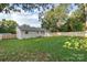 View of home's back facade and spacious backyard enclosed by a new wooden fence at 4042 Uppergate Ln, Charlotte, NC 28215
