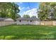 Back of house with fenced in yard surrounded by mature trees providing lots of shade at 4042 Uppergate Ln, Charlotte, NC 28215