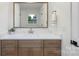 Bathroom with a window, marble countertop and brown cabinets at 4042 Uppergate Ln, Charlotte, NC 28215