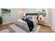 Comfortable bedroom with tufted headboard, two windows, wood floors, and side tables with lamps at 4042 Uppergate Ln, Charlotte, NC 28215