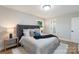 Bright bedroom featuring a tufted headboard, neutral decor, and light wood floors at 4042 Uppergate Ln, Charlotte, NC 28215