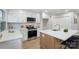 Well-lit kitchen featuring white cabinetry, stainless steel appliances, and center island with bar stools at 4042 Uppergate Ln, Charlotte, NC 28215