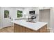 Bright kitchen with white cabinets, stainless steel appliances, and large island with quartz countertop at 4042 Uppergate Ln, Charlotte, NC 28215