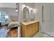 Bright bathroom featuring double sinks, wooden vanity and view to the bedroom at 413 Hurston Cir, Charlotte, NC 28208