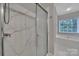 Bright bathroom featuring glass shower, tub and window at 413 Hurston Cir, Charlotte, NC 28208