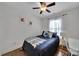 Comfortable bedroom featuring hardwood floors, a ceiling fan, two floral prints and a cozy bed with throw blanket at 413 Hurston Cir, Charlotte, NC 28208