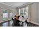 Open dining room with a dark wood table set for six beneath large windows and a view to the backyard at 413 Hurston Cir, Charlotte, NC 28208