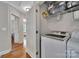 Efficient laundry area with a washer and dryer, storage shelves, and hardwood floors at 413 Hurston Cir, Charlotte, NC 28208