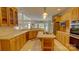 Bright kitchen featuring wood cabinets, tile flooring, cooktop island, and natural light from large windows at 495 Bay Harbour Rd, Mooresville, NC 28117