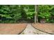 Fenced backyard area with a path leading to the woods and stacked firewood at 508 Flour Mill Ct, Fort Mill, SC 29715