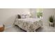 Neutral bedroom with floral-patterned bedding and a window that lets in natural light at 508 Flour Mill Ct, Fort Mill, SC 29715