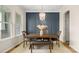 Stylish dining room with a modern chandelier, wainscotting, and a wooden dining table at 508 Flour Mill Ct, Fort Mill, SC 29715