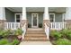 Welcoming front porch with brick steps, white railings, and lush landscaping leading to the front door at 508 Flour Mill Ct, Fort Mill, SC 29715