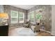 Inviting sitting room featuring patterned wallpaper, comfortable chairs, and ample natural light from multiple windows at 508 Flour Mill Ct, Fort Mill, SC 29715