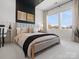 Cozy bedroom features neutral decor, plush bedding, and great natural light from a large window at 5512 Swaling St, Charlotte, NC 28217