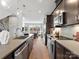 Modern kitchen with stainless steel appliances, an island sink, and a view of the open living space at 5512 Swaling St, Charlotte, NC 28217