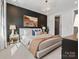 Primary bedroom with a textured accent wall, neutral décor, and an ensuite bathroom at 5512 Swaling St, Charlotte, NC 28217