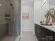 Bright bathroom featuring a glass-enclosed shower and double sink vanity with contemporary fixtures and decor at 5517 Swaling St, Charlotte, NC 28217