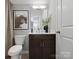 Elegant half-bath featuring neutral decor, dark vanity, toilet and decor, creating a stylish, compact space at 5517 Swaling St, Charlotte, NC 28217