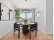 Dining room with a round table, black chairs, modern chandelier, and large window at 5735 Castlerea Dr, Charlotte, NC 28217