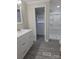 Bright bathroom featuring wood-look flooring, a large vanity and a shower with built in shelving at 6006 White Store Rd, Marshville, NC 28103