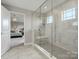 Elegant bathroom with a glass enclosed shower, open to the serene main bedroom at 6012 Millbridge Pkwy, Waxhaw, NC 28173