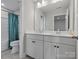 Bright bathroom with a double sink vanity, white cabinets, and a shower with a teal curtain at 6012 Millbridge Pkwy, Waxhaw, NC 28173