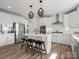 Bright kitchen boasts an island with bar stools, stainless appliances, and natural lighting at 6012 Millbridge Pkwy, Waxhaw, NC 28173