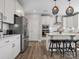Bright kitchen with white cabinetry, stainless steel appliances, and wood-look flooring at 6012 Millbridge Pkwy, Waxhaw, NC 28173