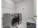 Functional laundry room equipped with modern washer and dryer units and shelving for storage at 6012 Millbridge Pkwy, Waxhaw, NC 28173