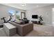 Cozy living space with a large sectional couch, TV, and natural light from the windows at 6012 Millbridge Pkwy, Waxhaw, NC 28173