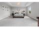 Open main bedroom showcases a wooden platform bed, neutral decor, and ample space at 6012 Millbridge Pkwy, Waxhaw, NC 28173