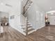 Elegant staircase with wooden steps, white railings, and hardwood flooring at 6012 Millbridge Pkwy, Waxhaw, NC 28173