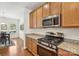 Modern kitchen showcasing stainless steel appliances, granite counters, and rich hardwood flooring at 6315 Prosperity Church Rd, Charlotte, NC 28269
