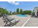 Relaxing pool area with lounge chairs for residents on a sunny day with lush trees at 6315 Prosperity Church Rd, Charlotte, NC 28269
