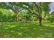 Large backyard with mature trees, green grass, and a chicken coop with shed at 6624 Lancer Dr, Charlotte, NC 28226