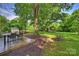 Picture perfect yard with mature trees, dining area, fire pit, and lush lawn at 6624 Lancer Dr, Charlotte, NC 28226