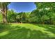 Expansive backyard surrounded by lush, mature trees and green grass at 6624 Lancer Dr, Charlotte, NC 28226