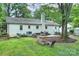 Spacious backyard featuring a white brick home, large patio, and lush green lawn at 6624 Lancer Dr, Charlotte, NC 28226