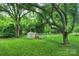 This backyard has plenty of space, mature trees, shed, chicken coop, and shade at 6624 Lancer Dr, Charlotte, NC 28226