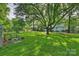 Expansive backyard featuring lush greenery, mature trees, and a chicken coop at 6624 Lancer Dr, Charlotte, NC 28226